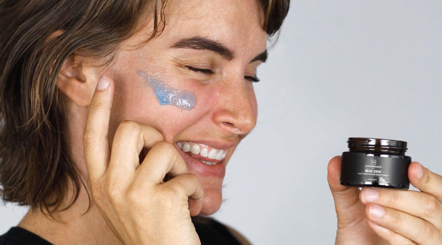 Woman applying withSimplicity Blue Dew Facial Moisturizer