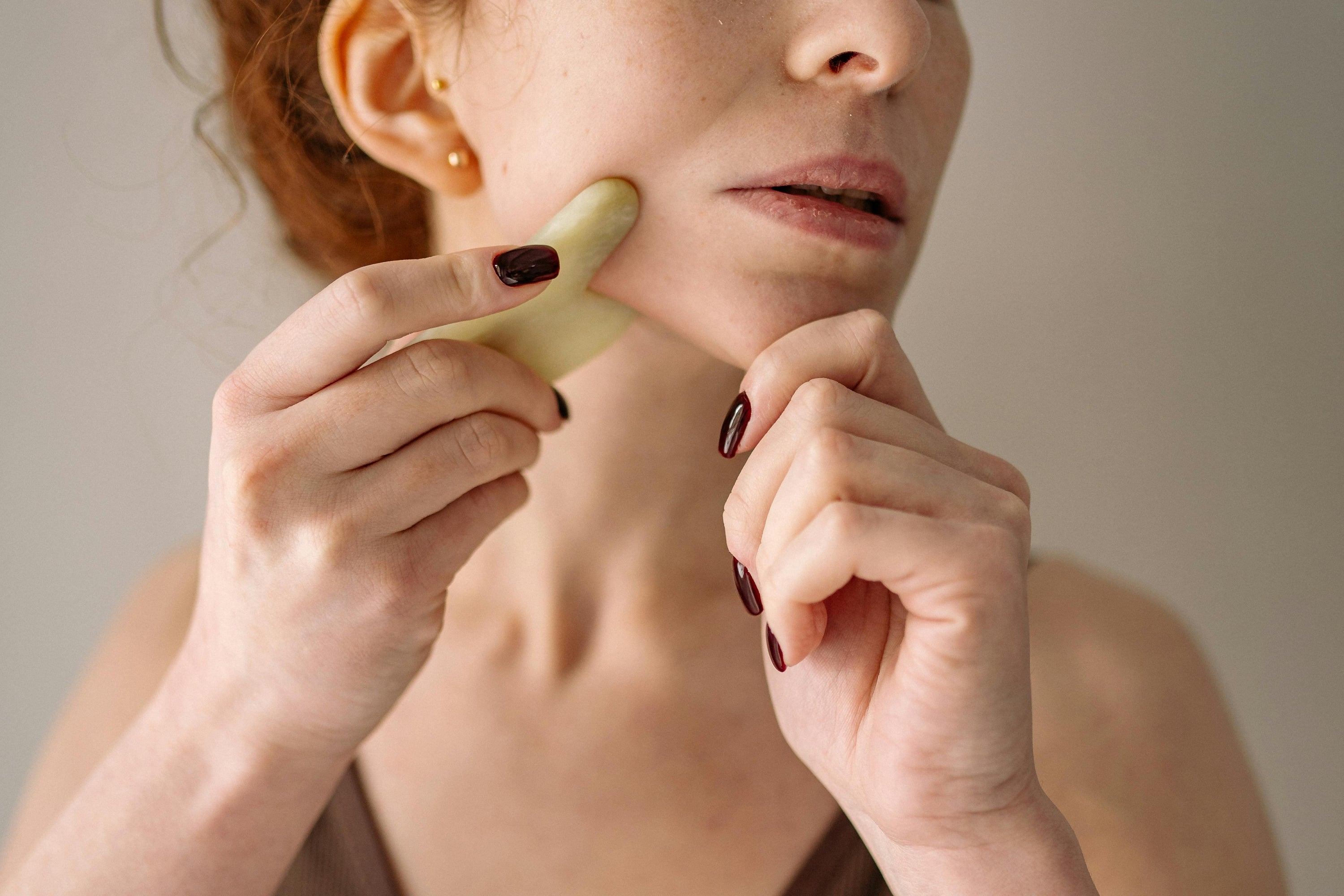woman using gua sha on face