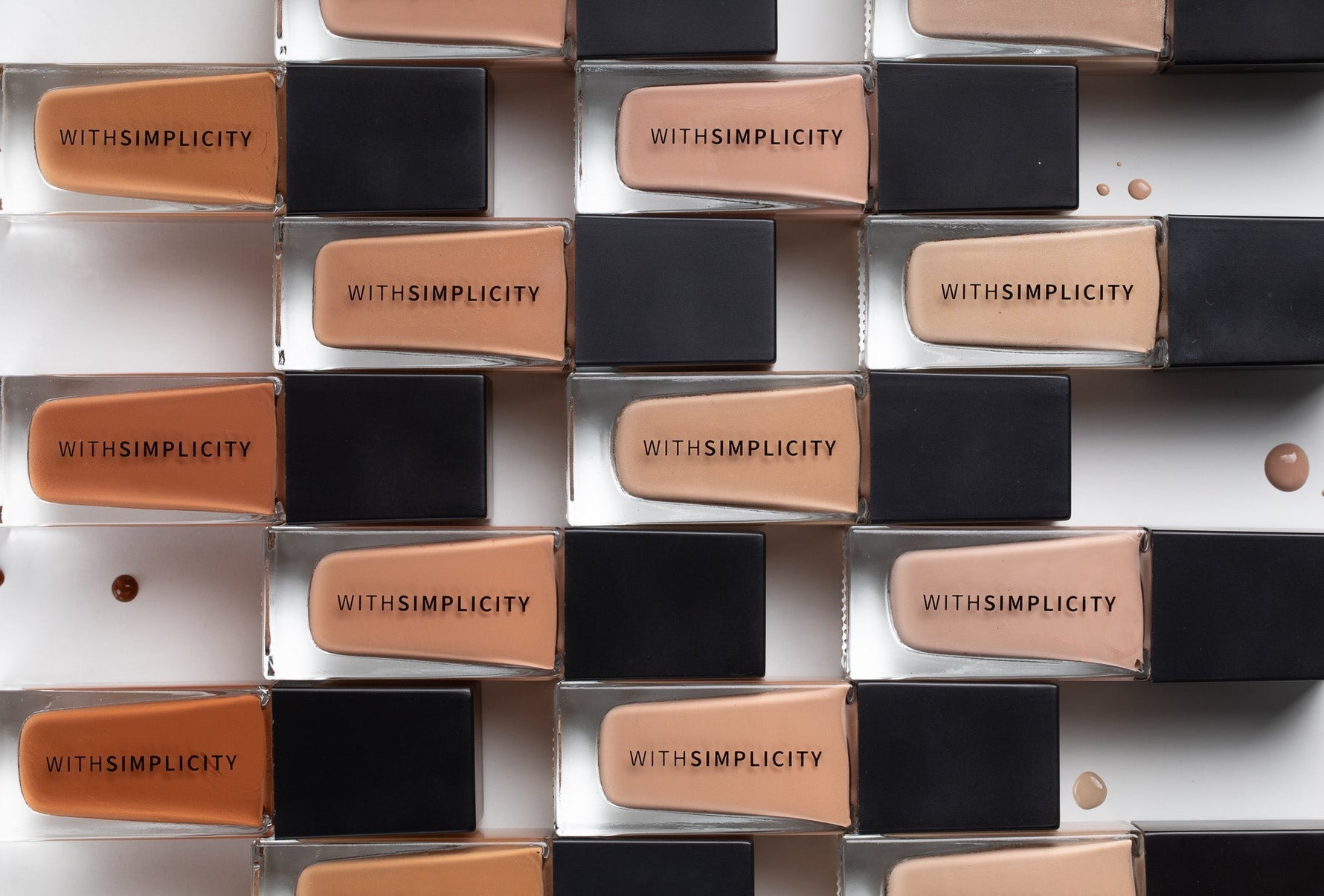 multiple withSimplicity foundation bottles in various shades on white background