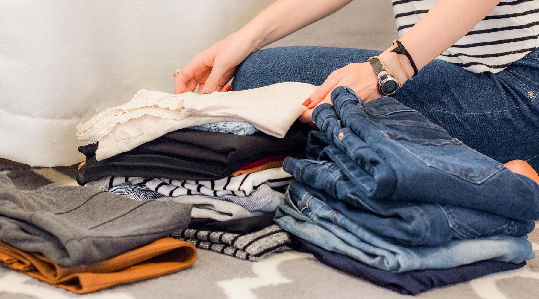 person folding clothes in neat piles