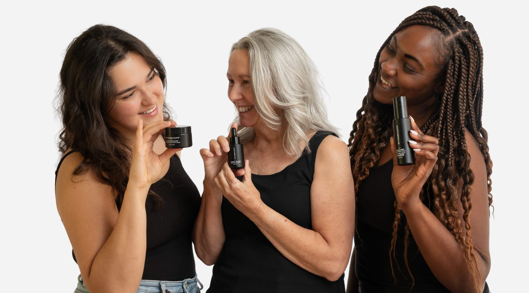 three women holding withSimplicity natural skincare products smiling at each other