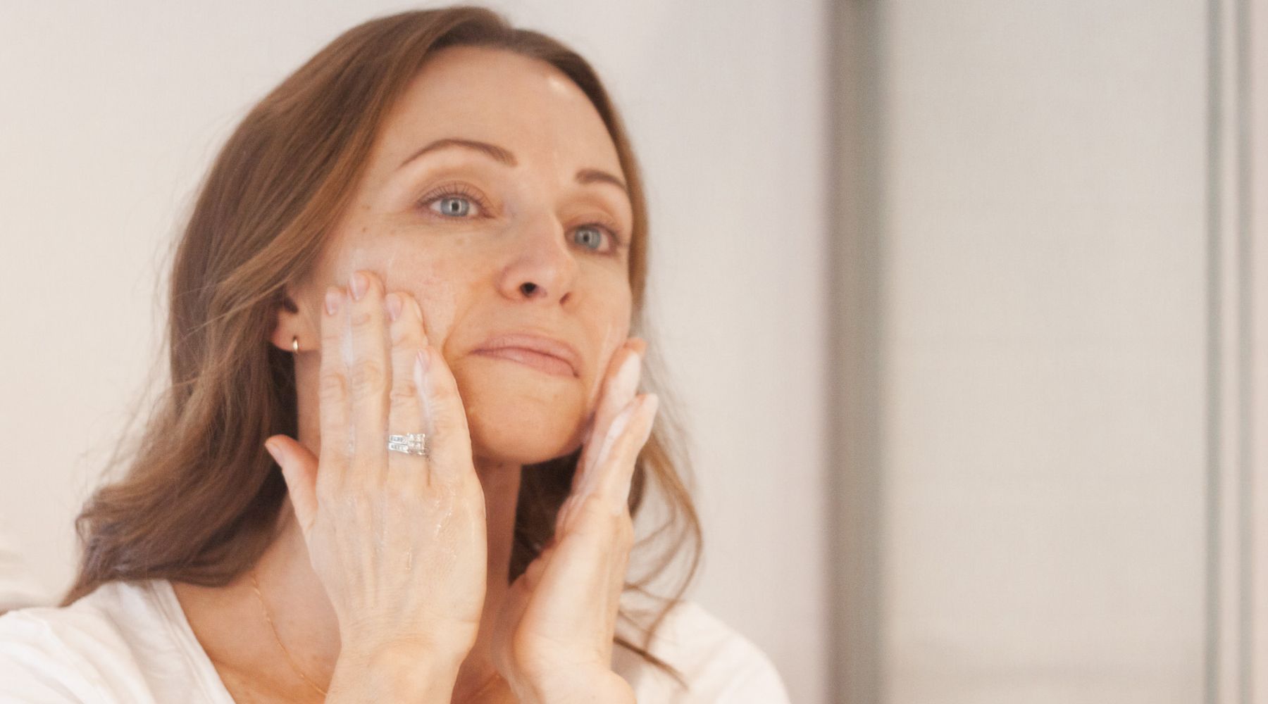 woman washing face with natural face cleanser