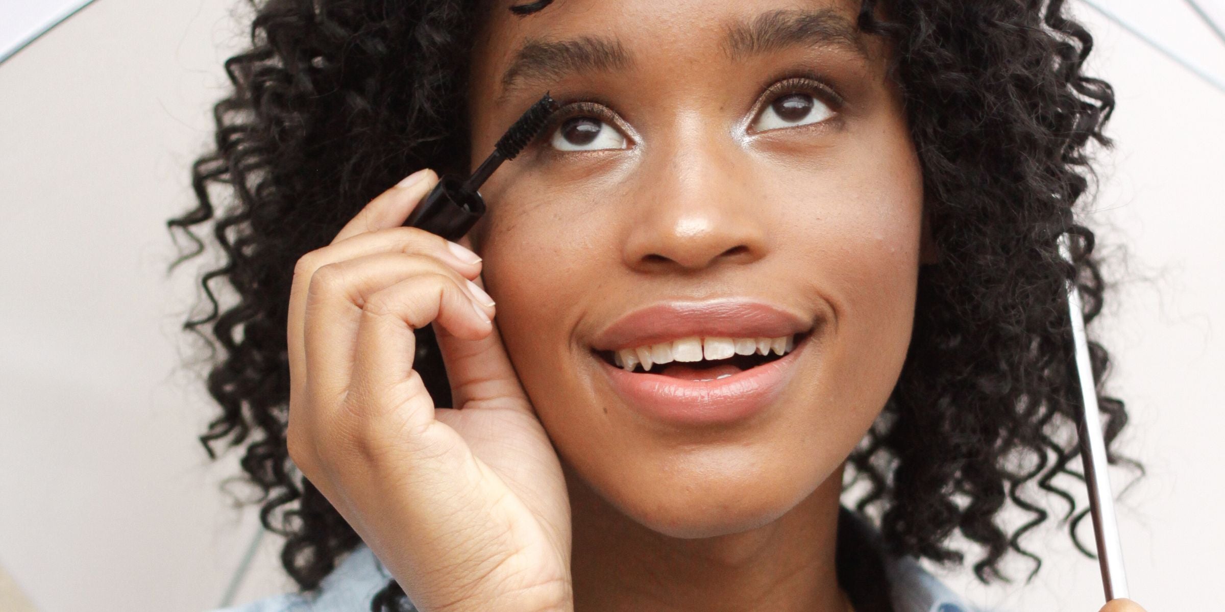 Girl applying mascara to lashes