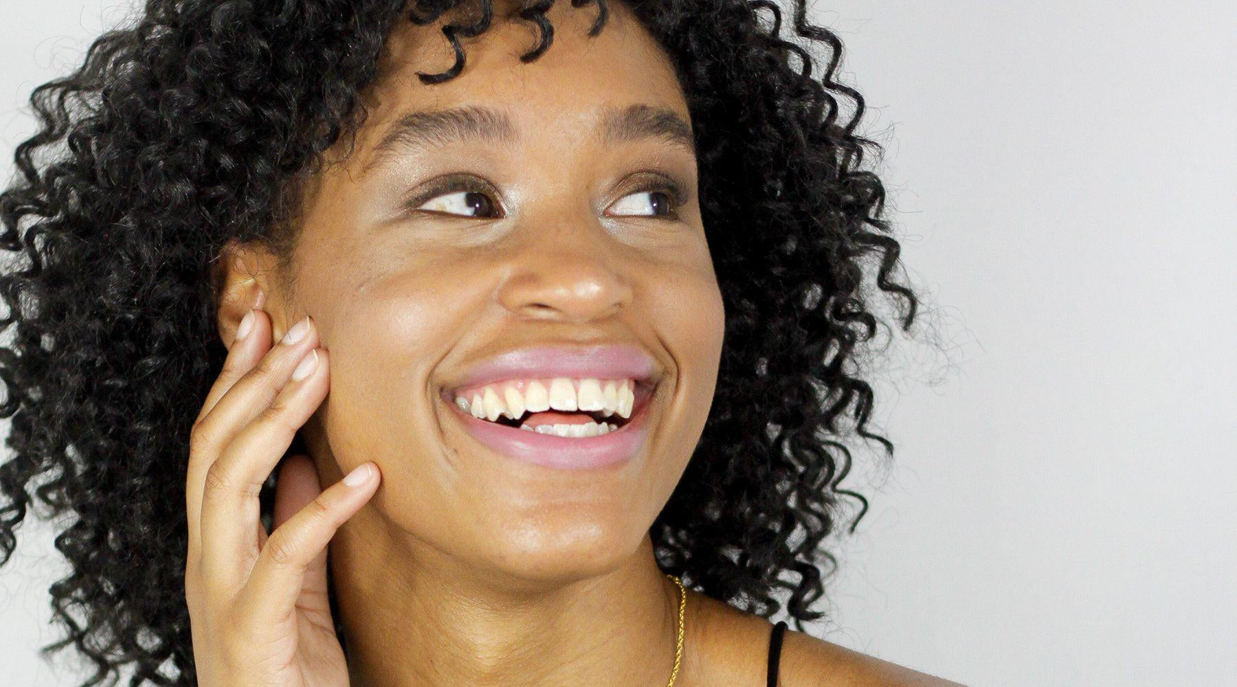 Girl smiling wearing a pink/purple lipstick from withSimplicity