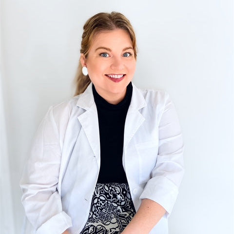 photo of woman with blonde hair wearing white lab coat against white background