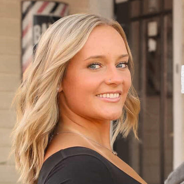 Woman with blonde hair smiling outdoors