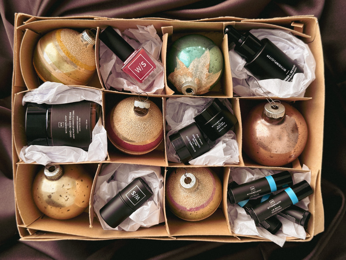 withSimplicity products and vintage christmas ornaments in a cardboard box against a silky brown background