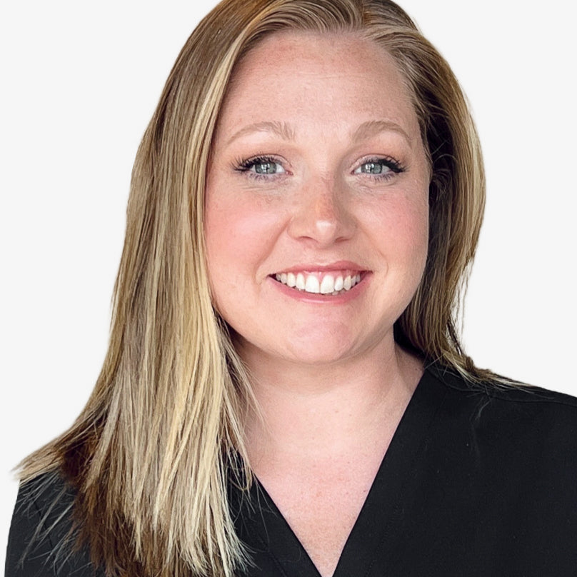 woman with blonde hair smiling against a light gray background
