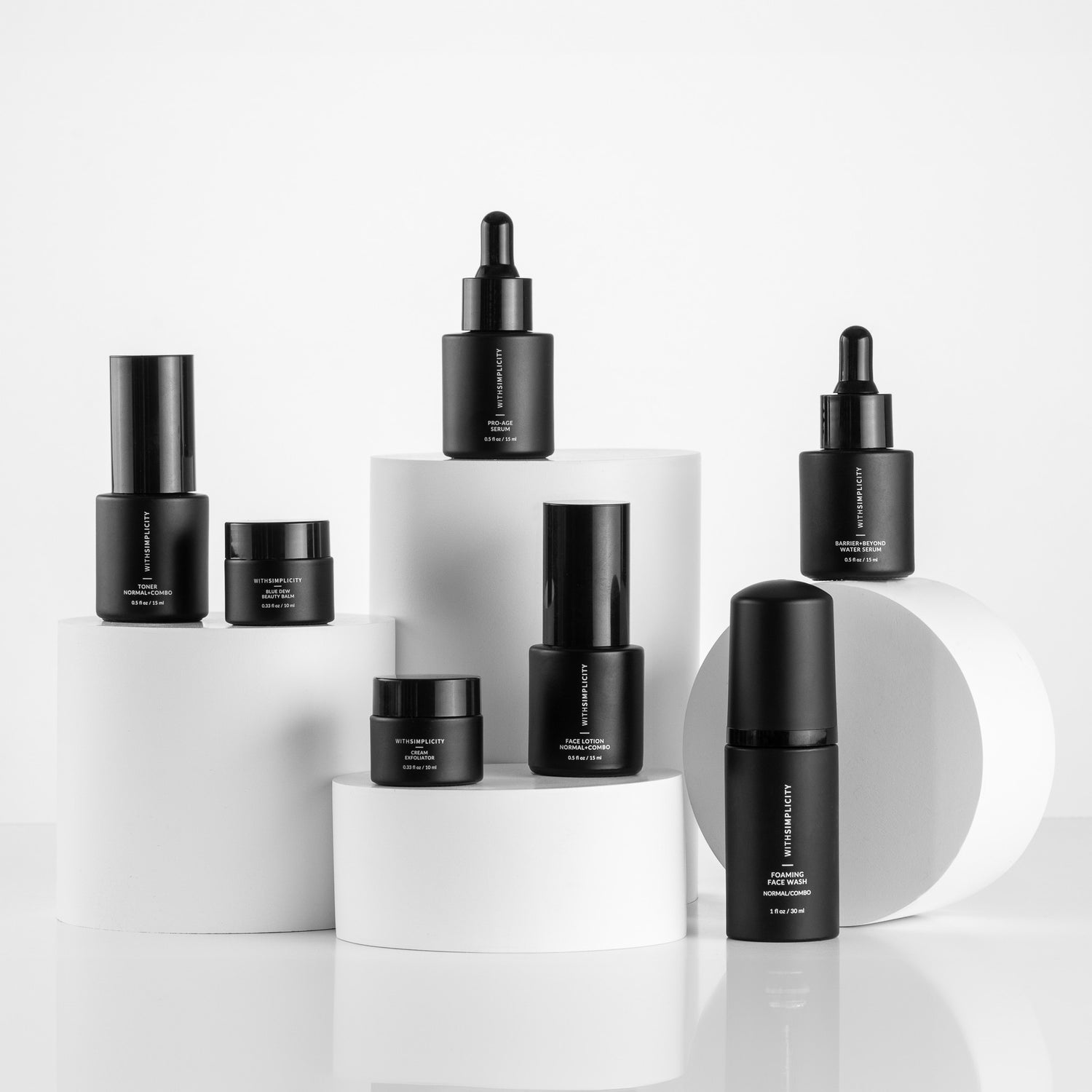 mini version withSimplicity skincare products on white risers on a light gray background.