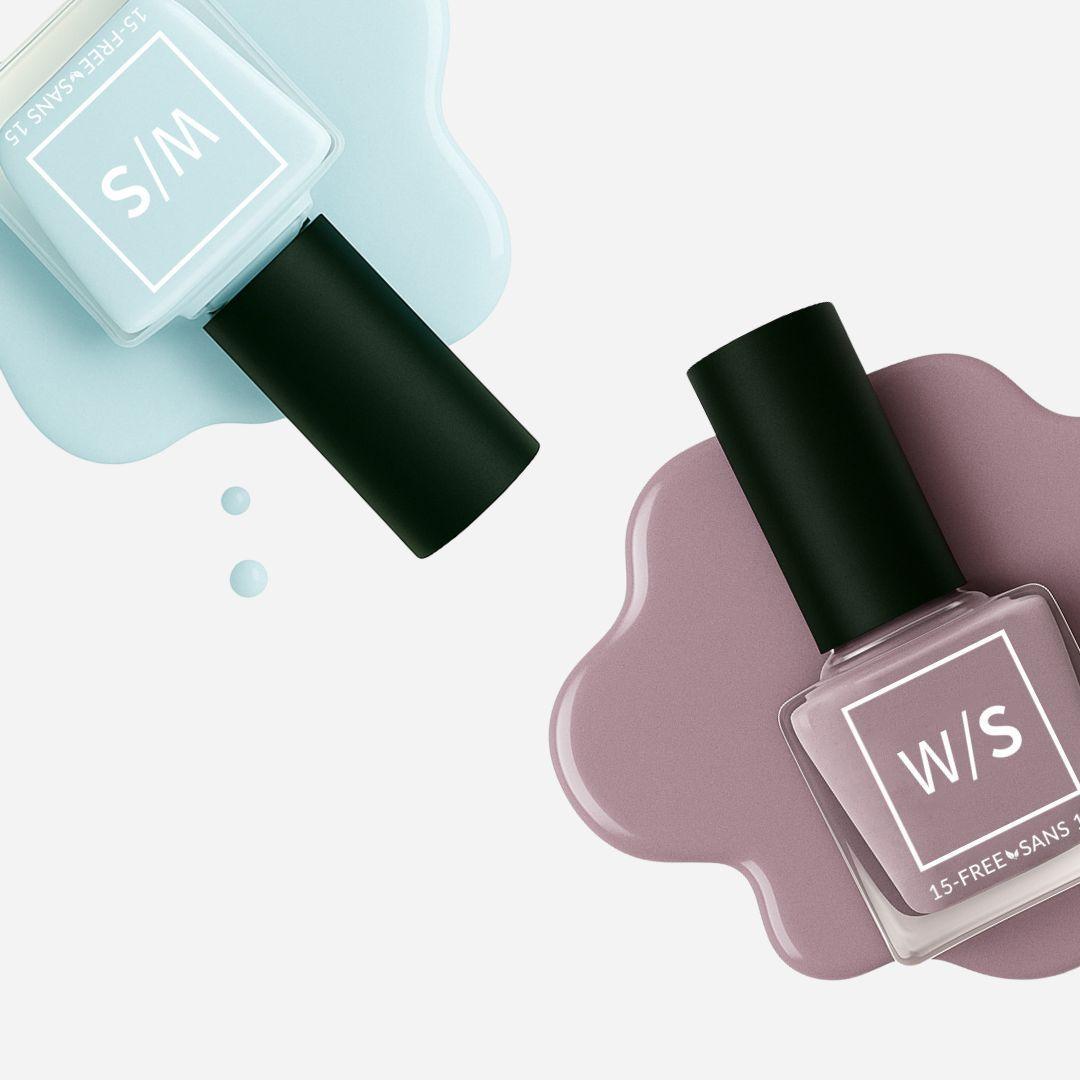 Two nail polish bottles, one light blue and one purple, on a white background.