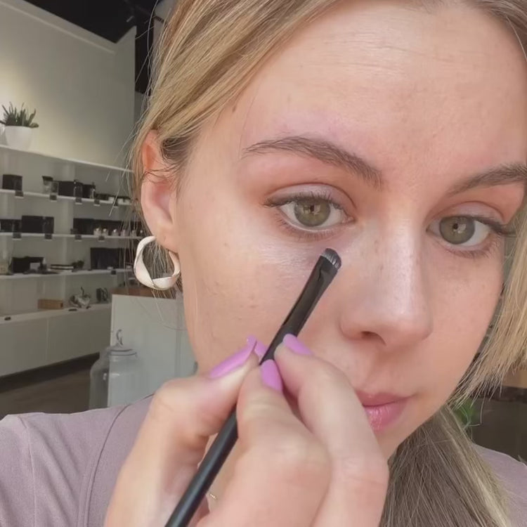 woman showing how to use the withSimplicity Under Eye Color Corrector cream in a video