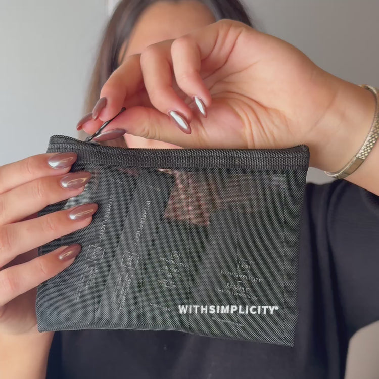 woman unwrapping withSimplicity Clean Start Makeup Kit and showing makeup products inside as well as putting them on her face.