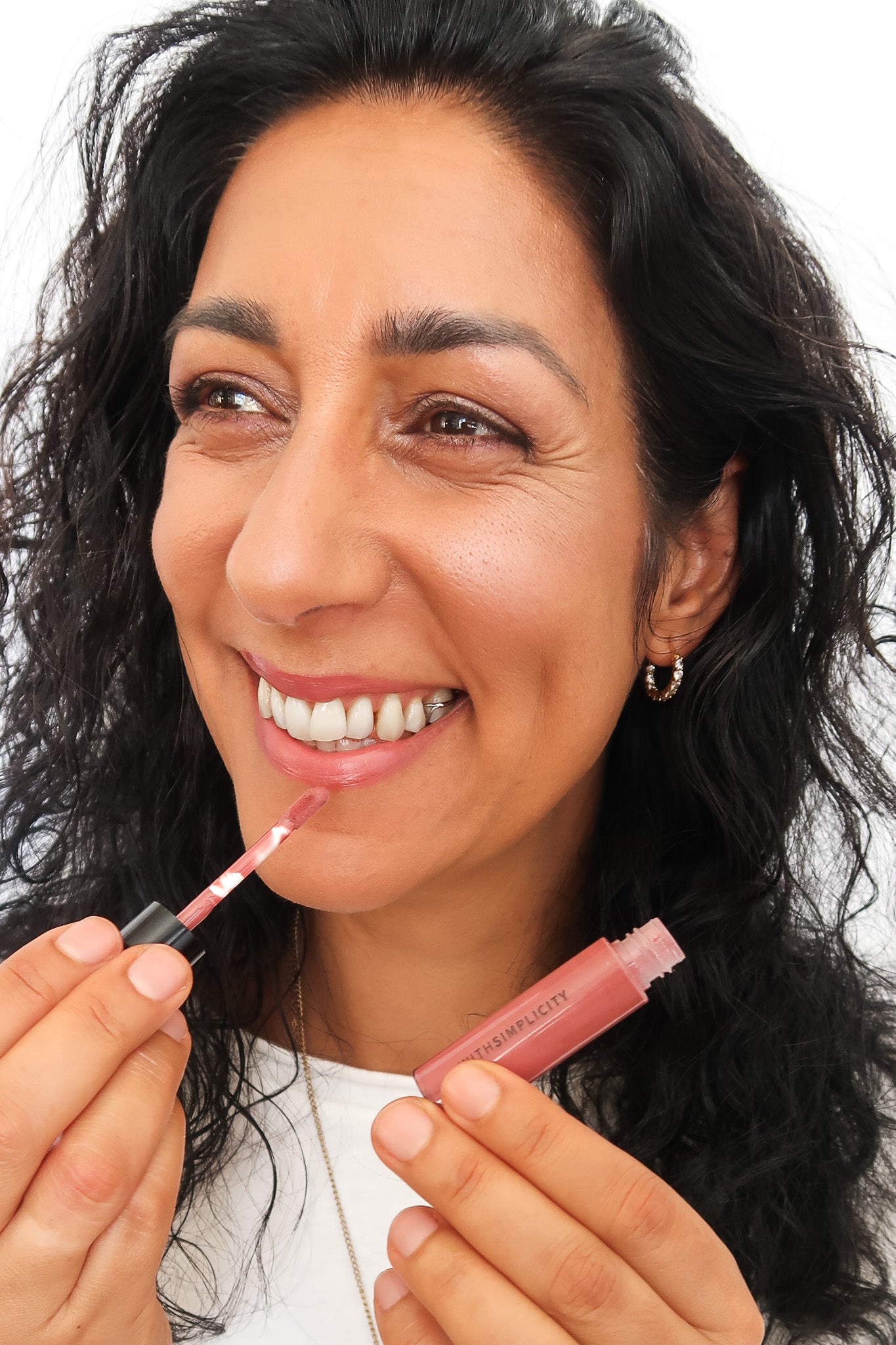 woman with brown hair and olive skin applying makeup. Text on screen says "want to accentuate brown eyes?"