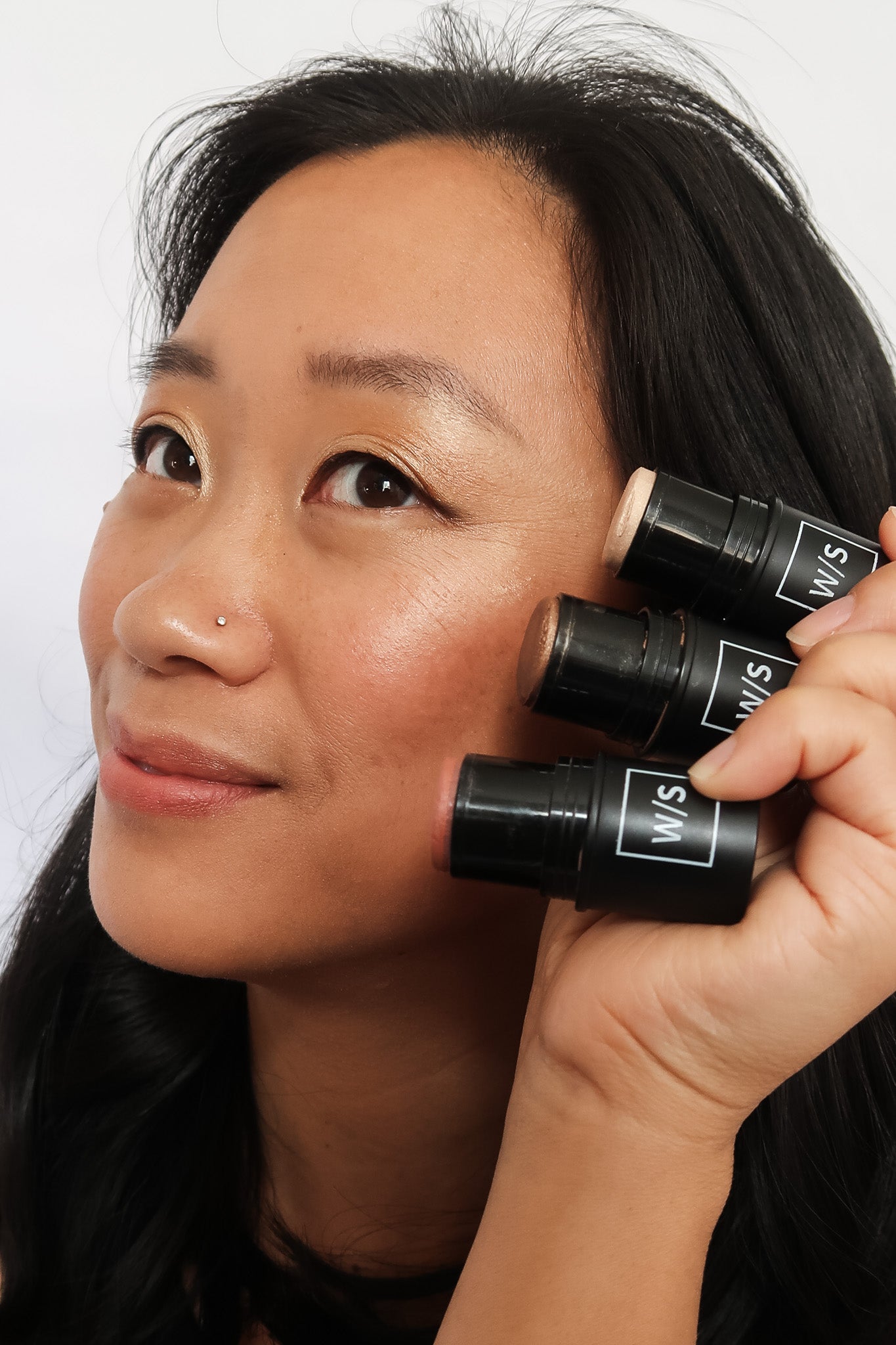 woman of asian decent having makeup applied to face
