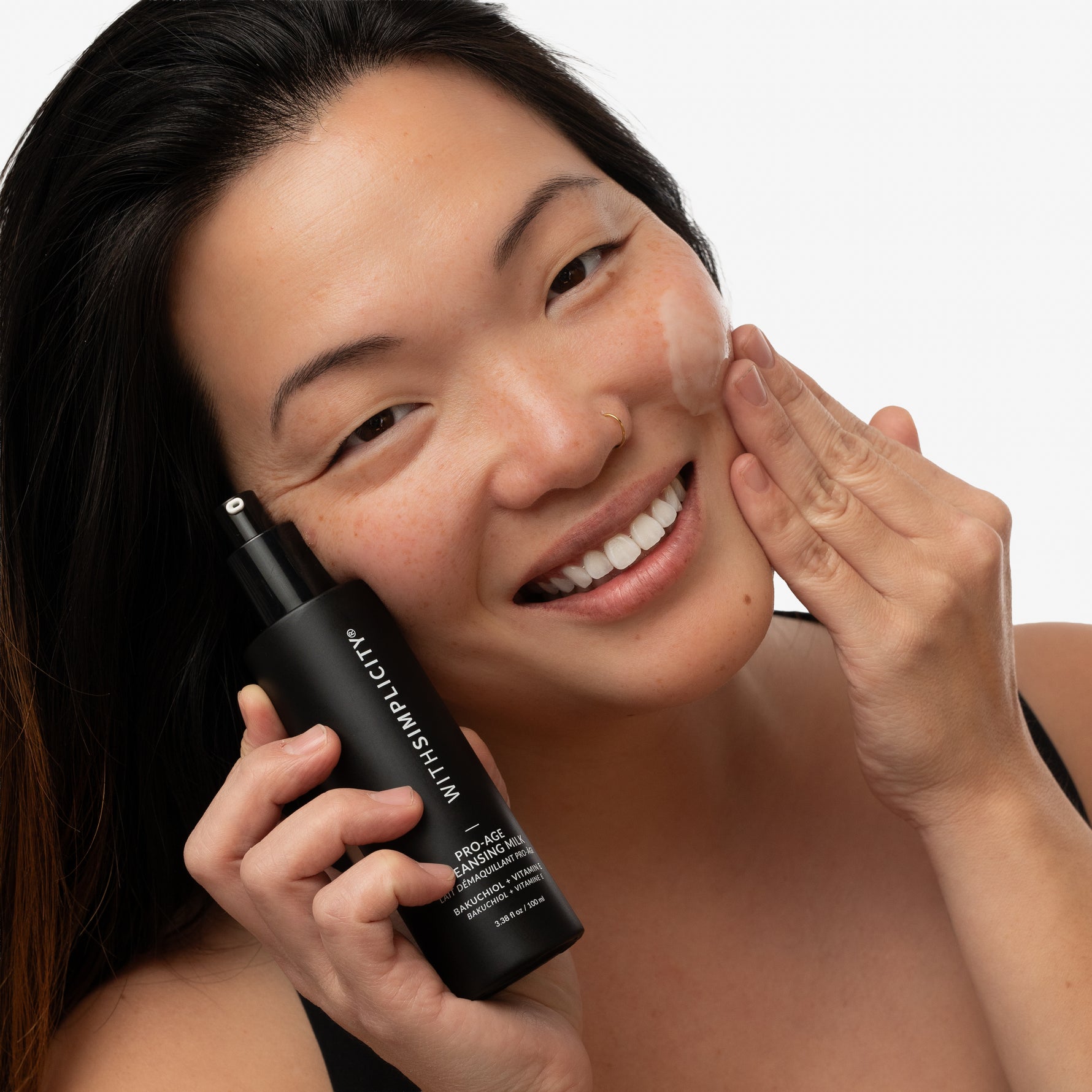 model applying withSimplicity bakuchiol cleanser to face