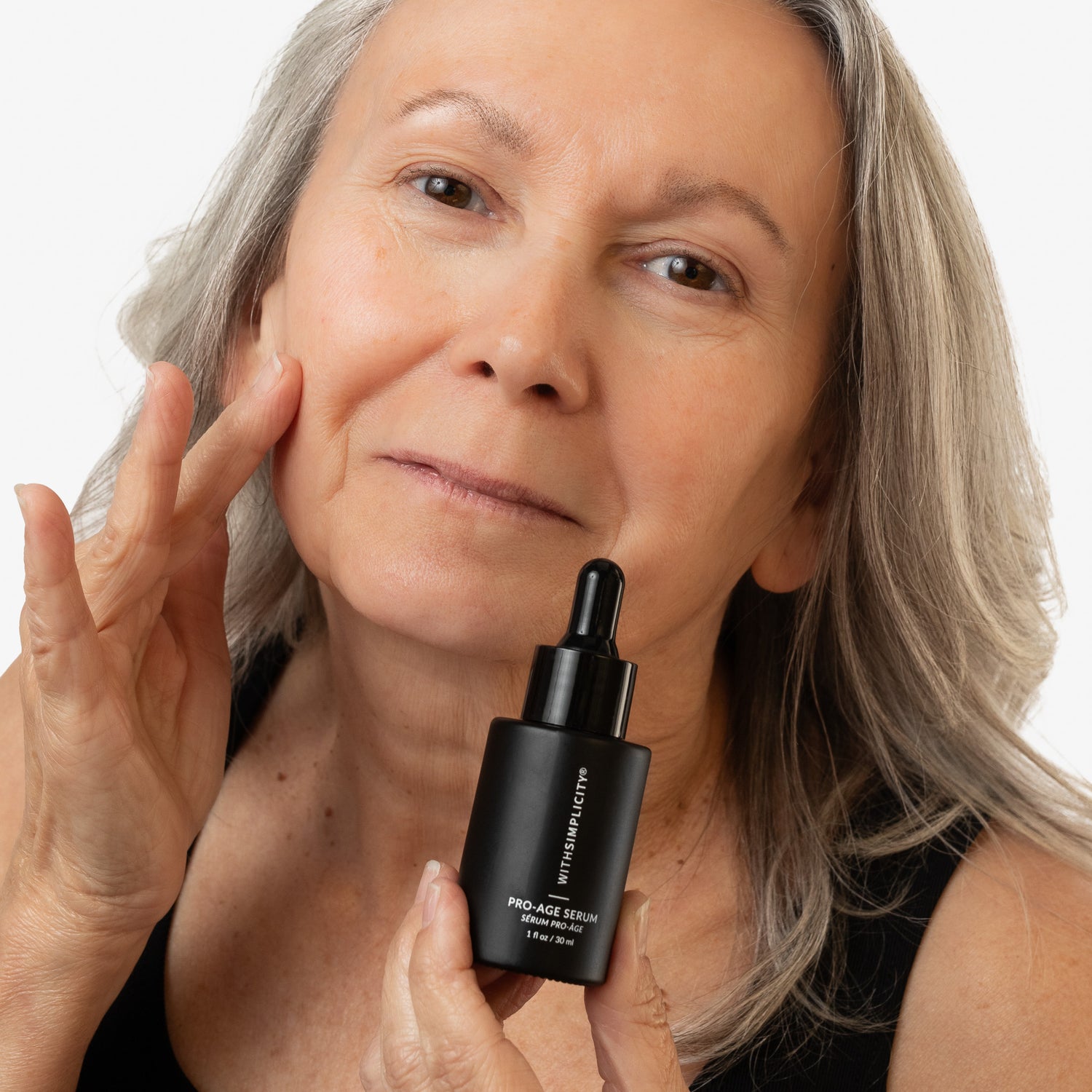 woman holding withSimplicity Pro-Age Serum bottle