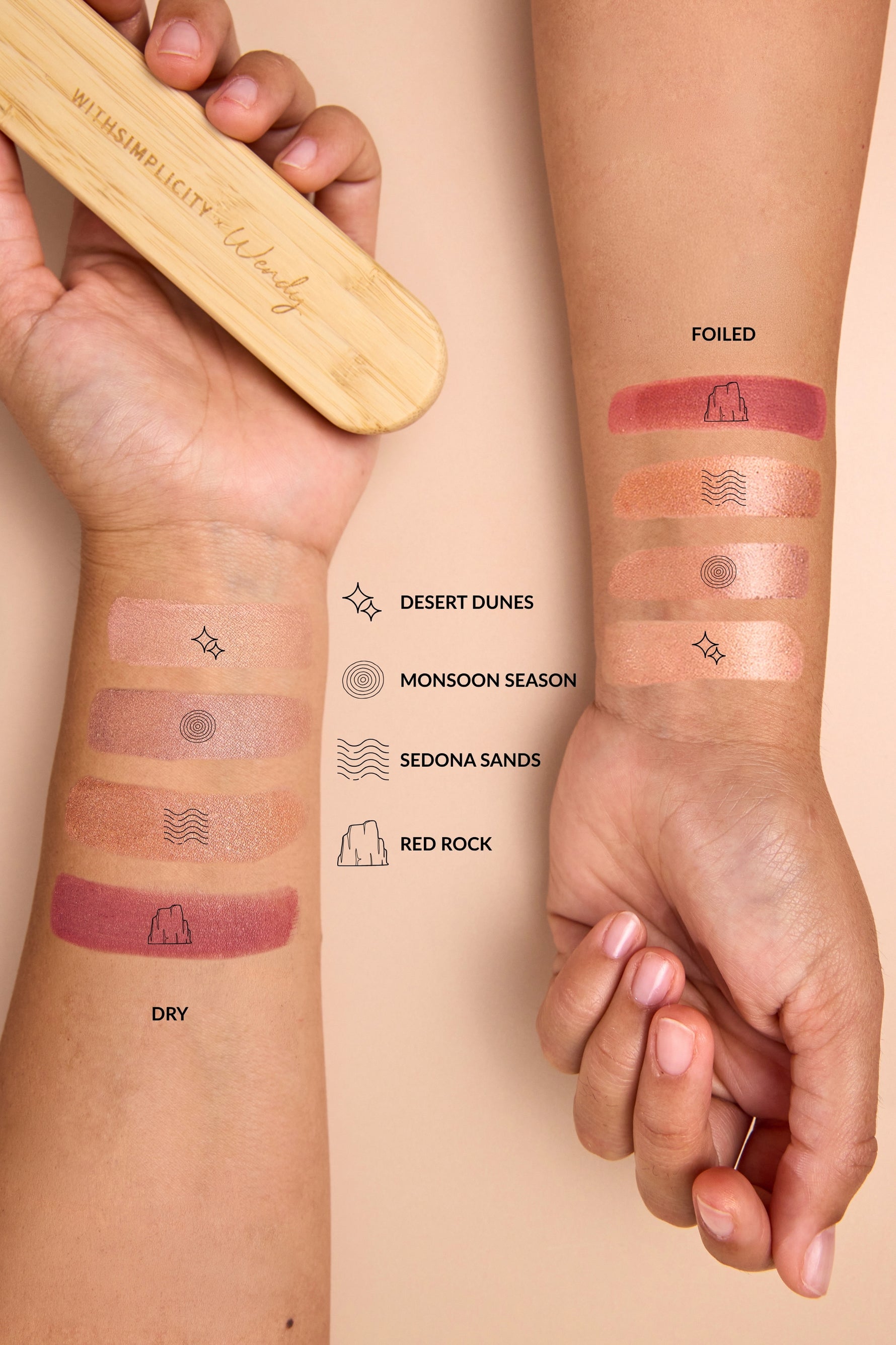 Two hands with makeup swatches on the forearms, showing different finishes and shades of a cosmetic product. A wooden eye palette is held in the left hand, and text labels identify the shades as Desert Dunes, Monsoon Season, Sedona Sands, and Red Rock