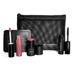 Makeup set with various products and a black pouch on a white background