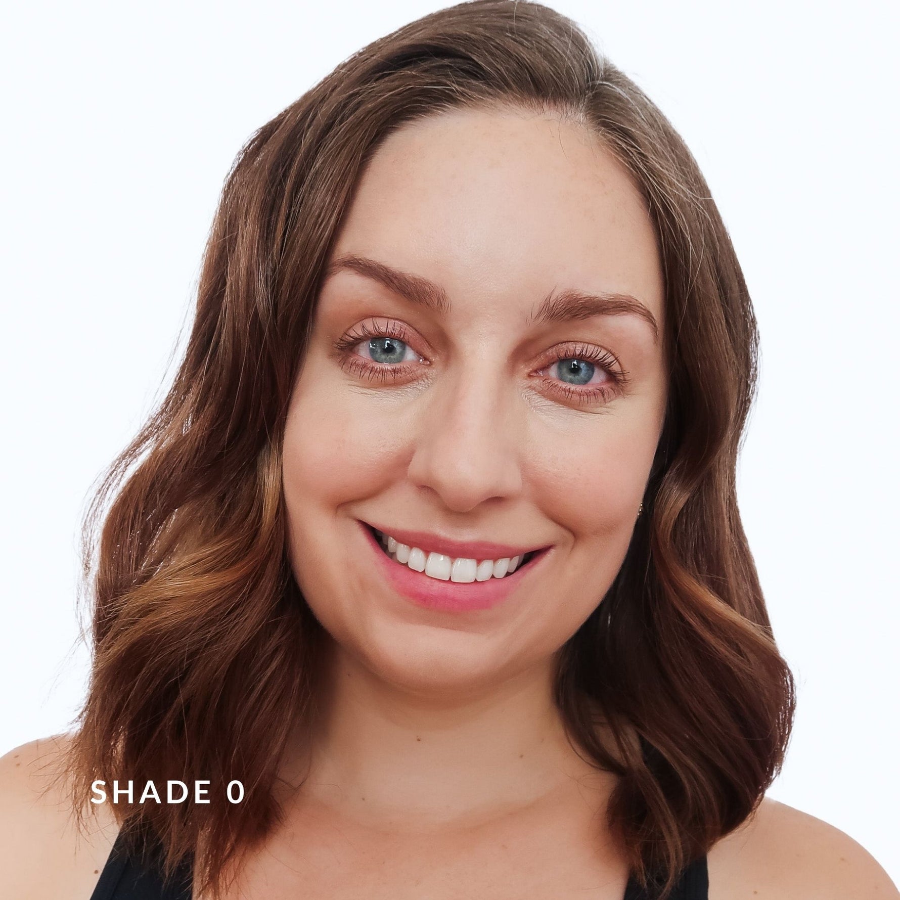 Woman with brown hair and blue eyes on a white background. says Shade 0