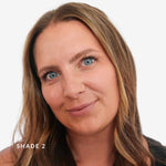 Woman with blonde hair and blue eyes on a white background. Text says Shade 2