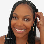 Woman with braided hair smiling against a plain background. Text says Shade 7