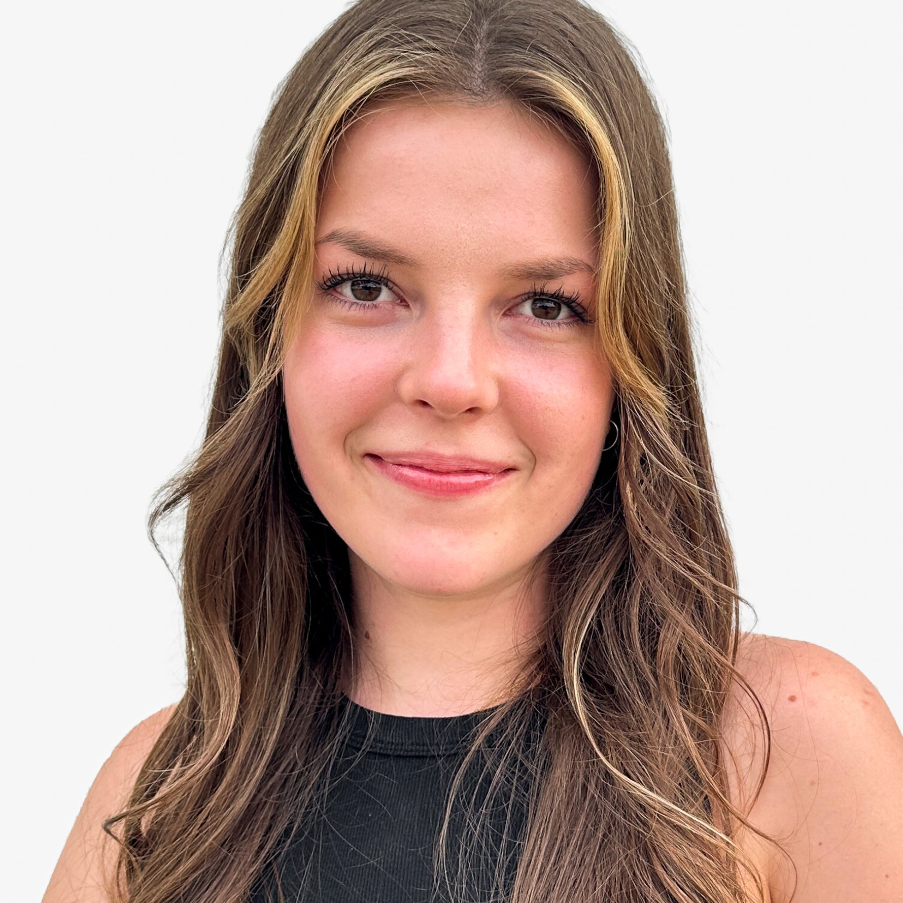 Woman with long brown hair smiling against a white background